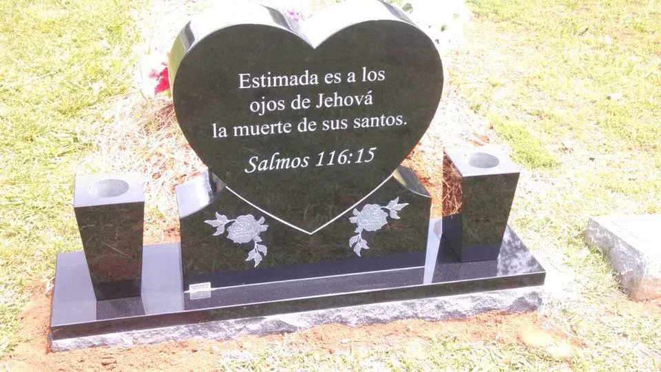 A heart-shaped polished memorial with a Spanish inscription and decorative details
