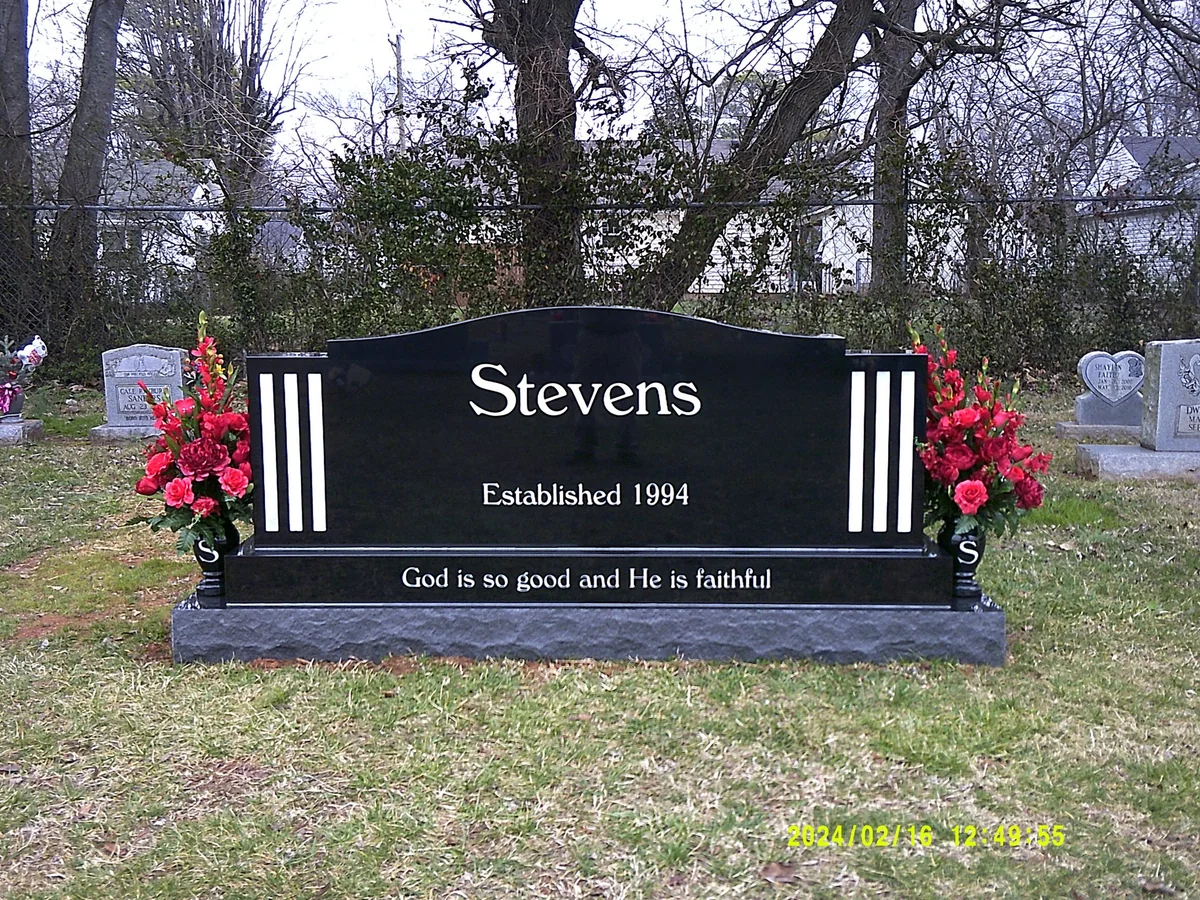 A black Stevens upright with bright lettering, vertical accents and red flowers