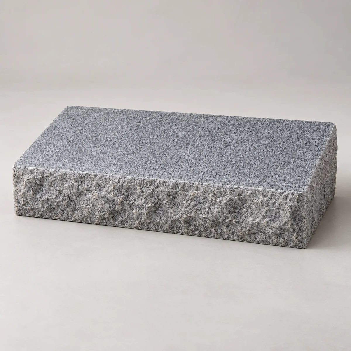 Blank low granite bevel marker with a gently sloping polished top and rough stone edges