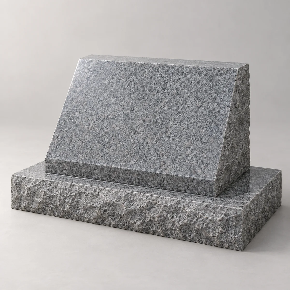 Blank granite slant with a steep polished face and visible wedge profile on a separate low base