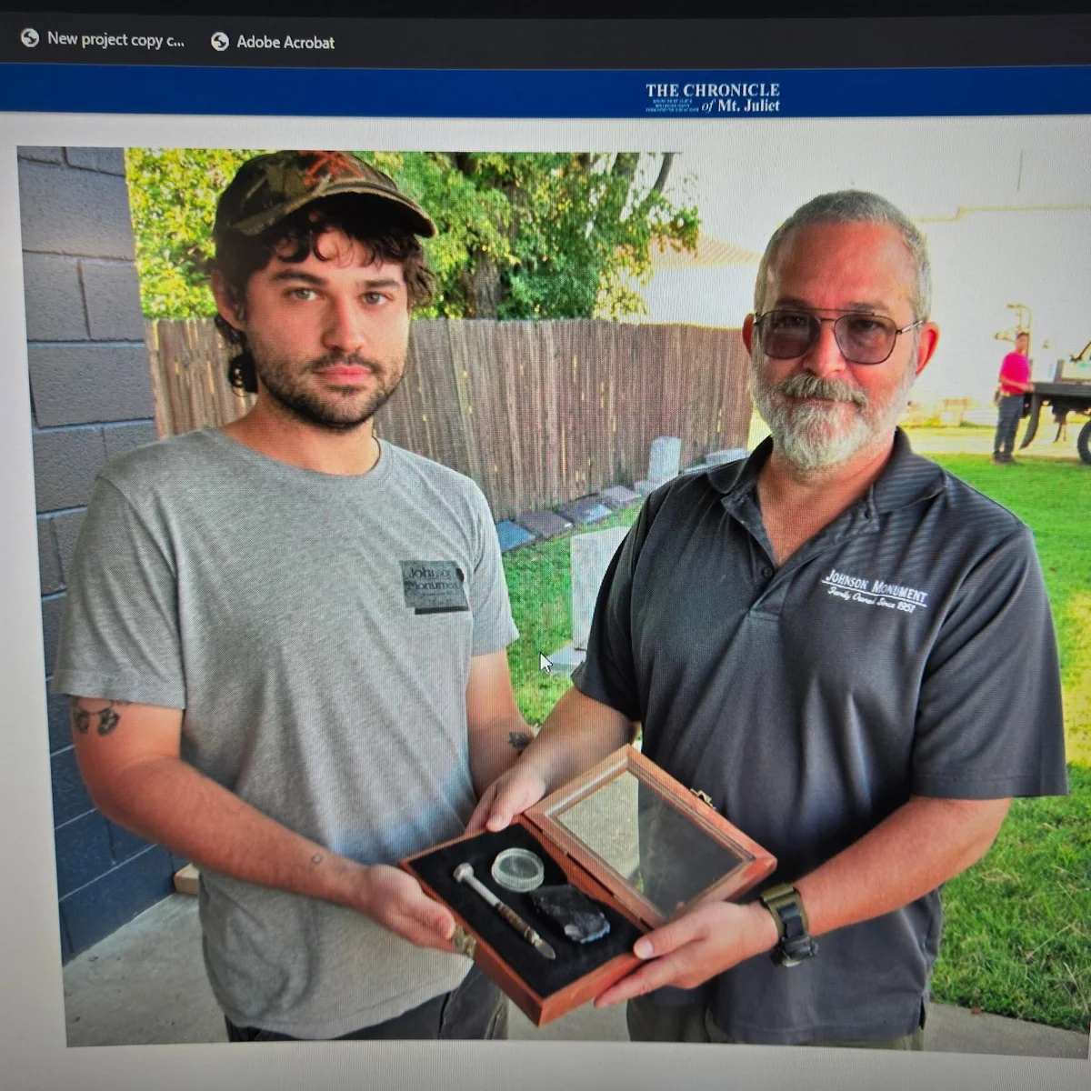 Archive newspaper photograph of two men holding a framed award together