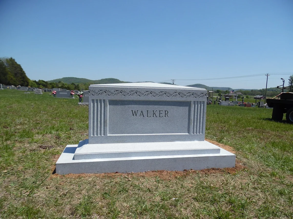The Walker granite memorial with fluted side columns, a carved border and a broad stepped base
